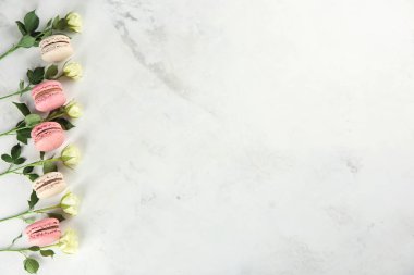 Lezzetli macarons ve açık renkli güllerinin düz yatıyordu kompozisyonu