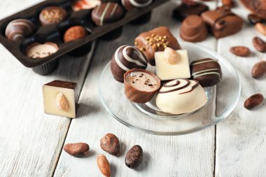 Ahşap masa üzerinde lezzetli çikolata şekerleme ile plaka