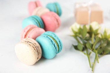 Lezzetli macarons ve açık renkli gül