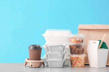 Farklı paketleri masasına renk arka plan karşı lezzetli yemek ile. Teslimat hizmeti