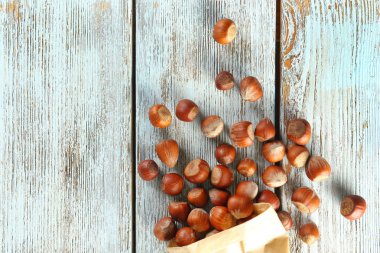 Lezzetli fındık ve kağıt paket üzerinde ahşap arka plan, üstten görünüm