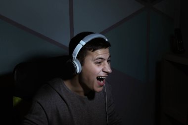 Genç evde video oyunları oynarken karanlıkta adam.