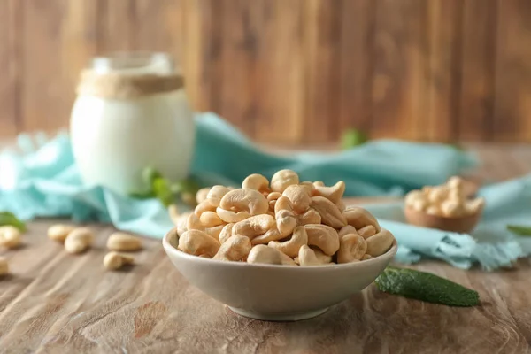 Plate with tasty cashew nuts on wooden table — Stock Photo, Image