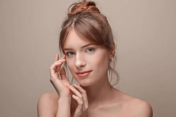 Belle jeune femme à la peau soyeuse sur fond gris — Photo