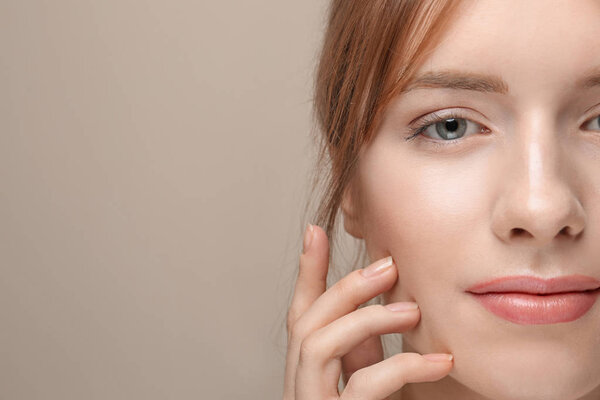 Beautiful young woman with silky skin on grey background, closeup