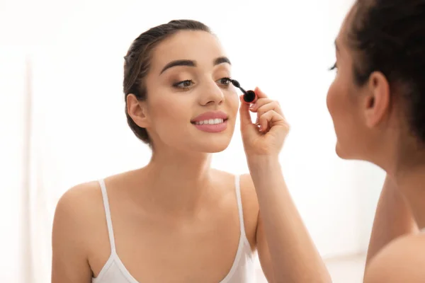 Mooie jongedame toepassing van make-up in ochtend — Stockfoto