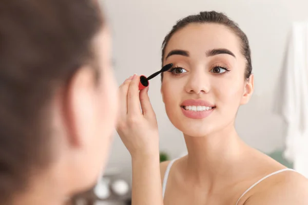 Jovem bela mulher aplicando maquiagem de manhã — Fotografia de Stock