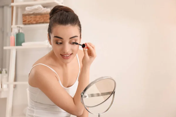 Jovem bela mulher aplicando maquiagem de manhã — Fotografia de Stock