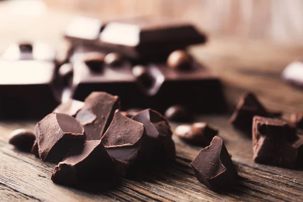 Pièces de chocolat noir sur table en bois — Photo