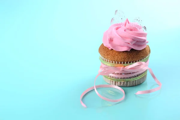 Tasty cupcake with pink ribbon on color background. Mother's Day celebration — Stock Photo, Image