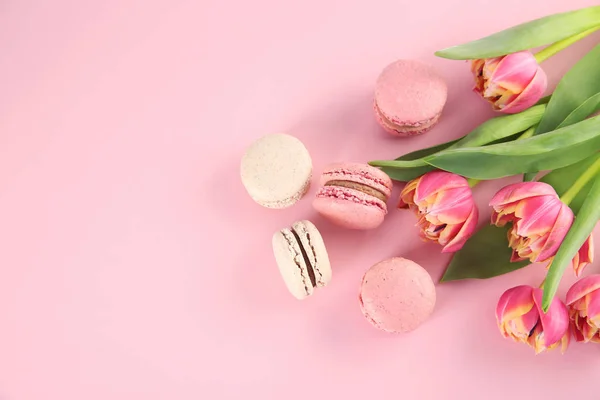 Läckra macarons och blommor på färgbakgrund — Stockfoto