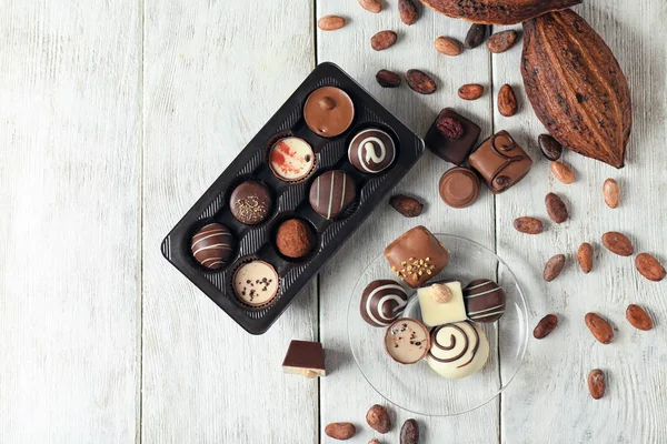 Красивая композиция с вкусными шоколадными конфетками на деревянном столе — стоковое фото
