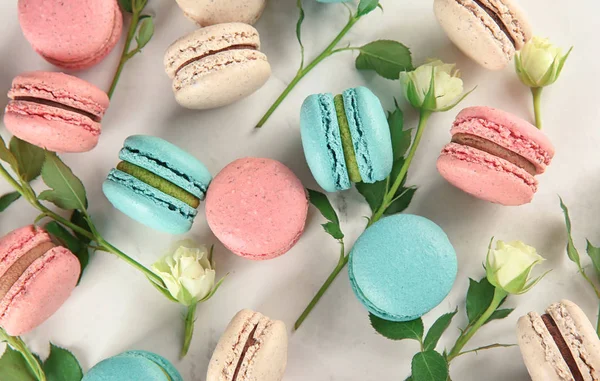 stock image Flat lay composition with tasty macarons and roses on light background