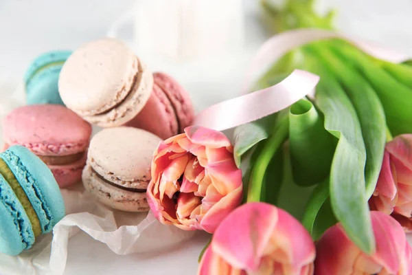 Tasty macarons and tulips on table — Stock Photo, Image