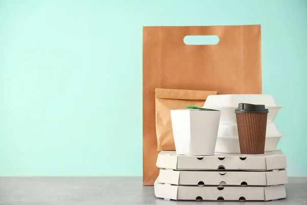 Verschillende pakketten op tafel tegen een achtergrond met kleur. Levering foodservice — Stockfoto