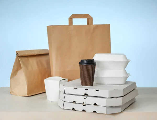 Różne pakiety na stole przed kolor tła. Dostawa żywności — Zdjęcie stockowe