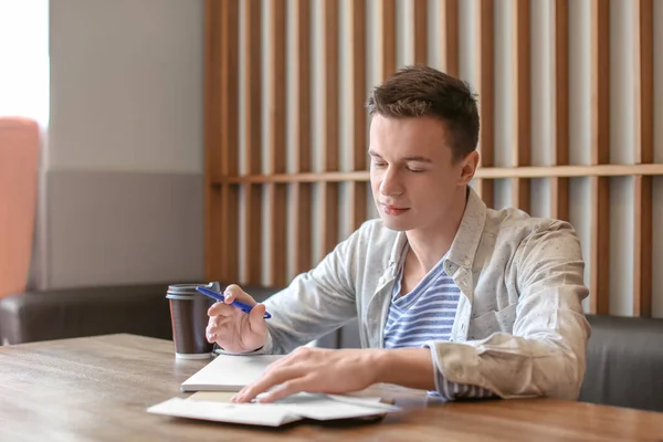 Young man writing letter at table in cafe. Mail delivery — Stock Photo, Image