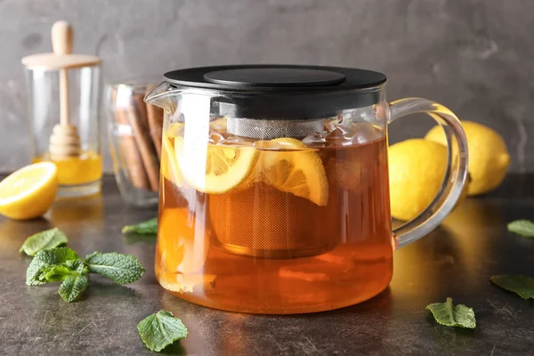 Teapot of delicious tea with ginger, lemon and ice on table — Stock Photo, Image