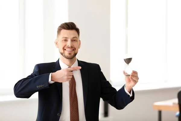 Empresário com ampulheta no escritório. Conceito de gestão do tempo — Fotografia de Stock