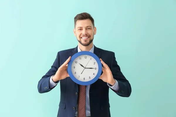 Geschäftsmann mit Uhr auf farbigem Hintergrund. Zeitmanagement-Konzept — Stockfoto