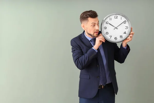 Geschäftsmann mit Uhr auf farbigem Hintergrund. Zeitmanagement-Konzept — Stockfoto