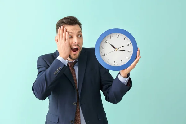 Affärsman med klockan på färgbakgrund. Time management koncept — Stockfoto