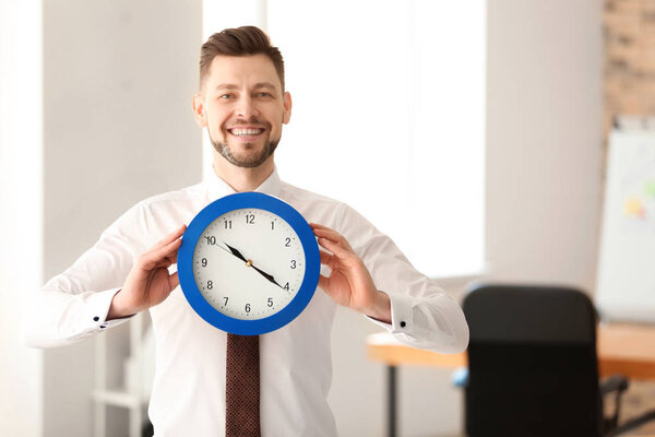 Businessman with clock in office. Time management concept