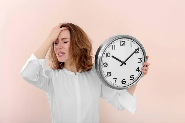 Mature woman with clock on color background. Time management concept — Stock Photo, Image