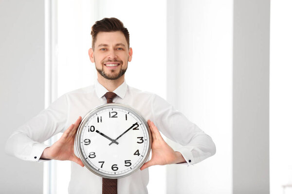 Businessman with clock in office. Time management concept