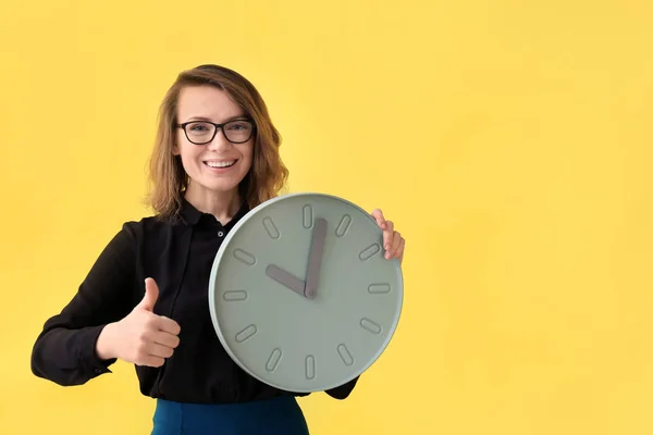 Mujer madura con reloj sobre fondo de color. Concepto de gestión del tiempo —  Fotos de Stock