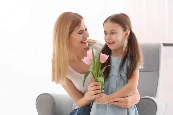 Madre recibiendo flores de su linda hija en casa — Foto de Stock