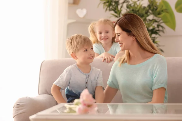 Portrait of smiling mother and her cute little children at home — Stock Photo, Image