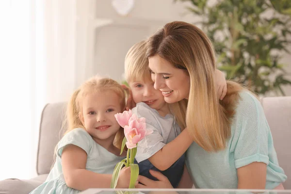 Мати отримує квіти від своїх милих маленьких дітей вдома — стокове фото