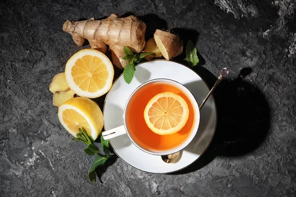 Cup of hot tea with ginger and lemon on table — Stock Photo, Image