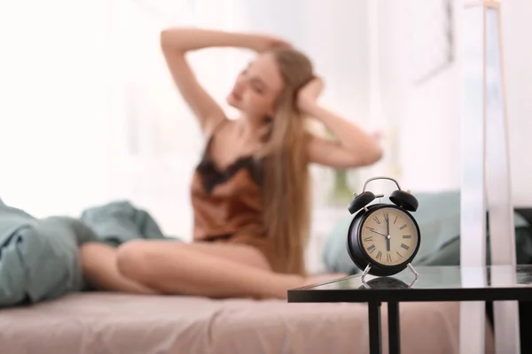 Alarm clock on table in bedroom of beautiful woman. Morning time — Stock Photo, Image