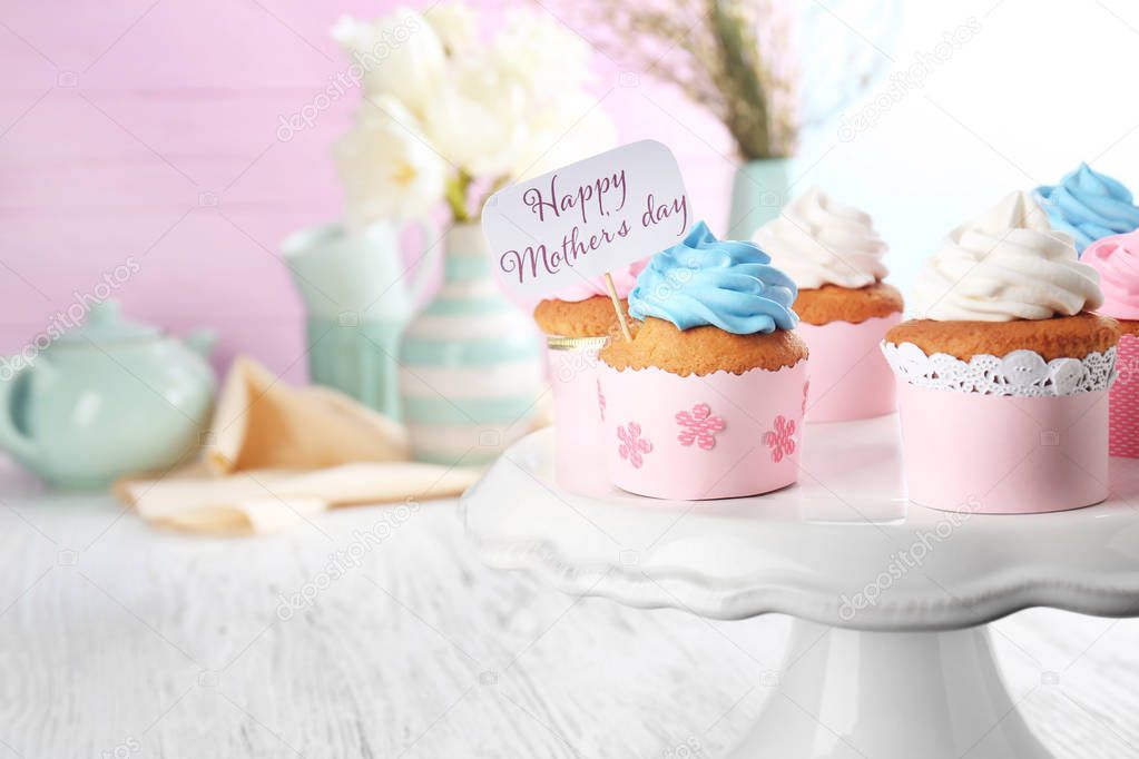 Tasty cupcakes and topper pick with words HAPPY MOTHER'S DAY on stand