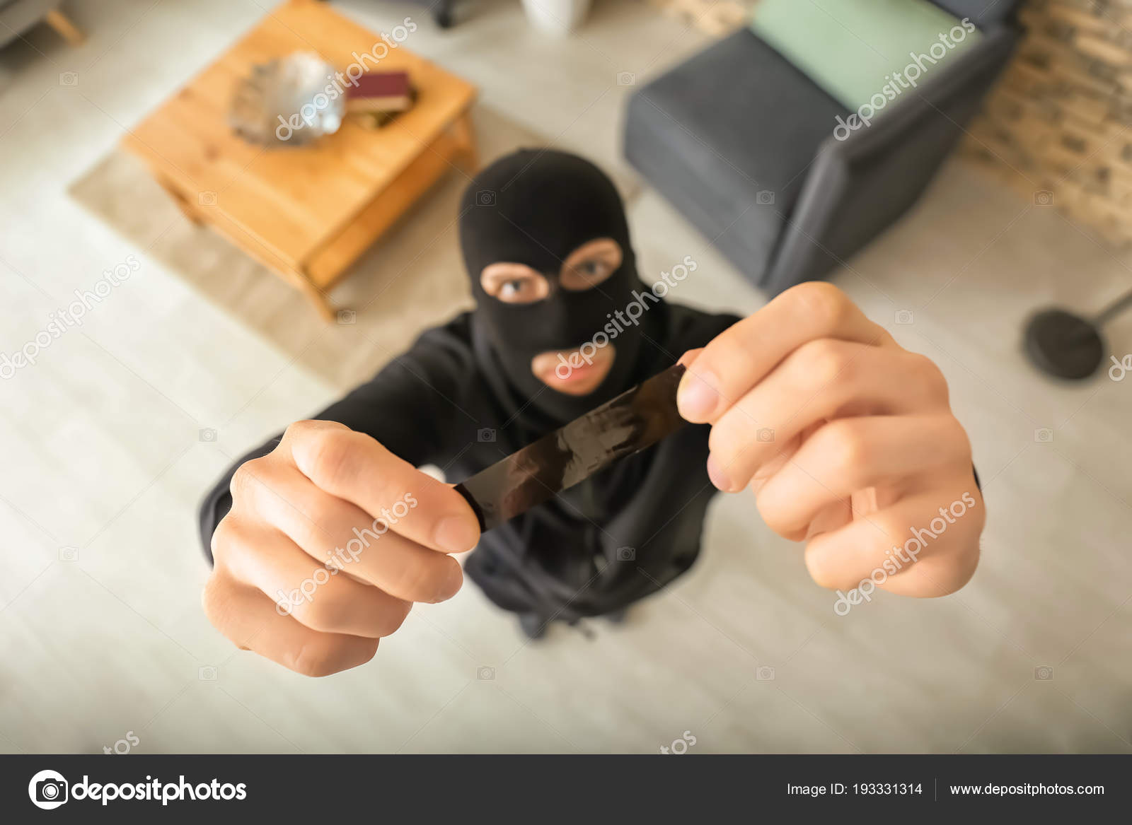 Thief with sticky tape is going to glue security camera indoors, top