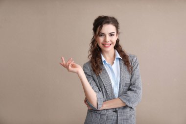 Renk arka plan üzerinde resmi giysili genç kadın