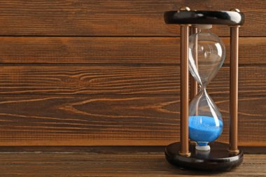 Ahşap arka plan üzerinde kum saati. Zaman yönetimi kavramı