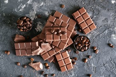 Gri arka plan üzerinde kahve çekirdekleri ile lezzetli çikolata