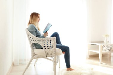 Genç kadın evde ilginç bir kitap okuma