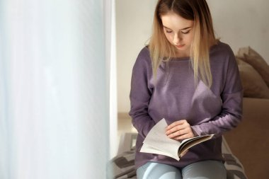 Genç kadın evde ilginç bir kitap okuma