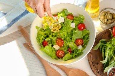 Tablo taze sebze salata bir kase içine zeytinyağı ekleyerek kadın