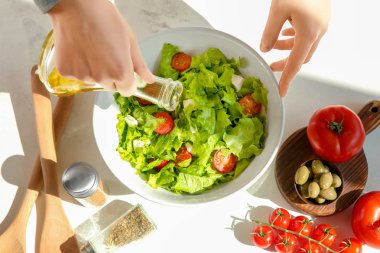 Tablo taze sebze salata bir kase içine zeytinyağı ekleyerek kadın