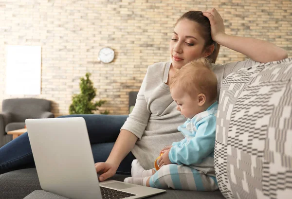 Ung mamma med baby arbetar hemma — Stockfoto