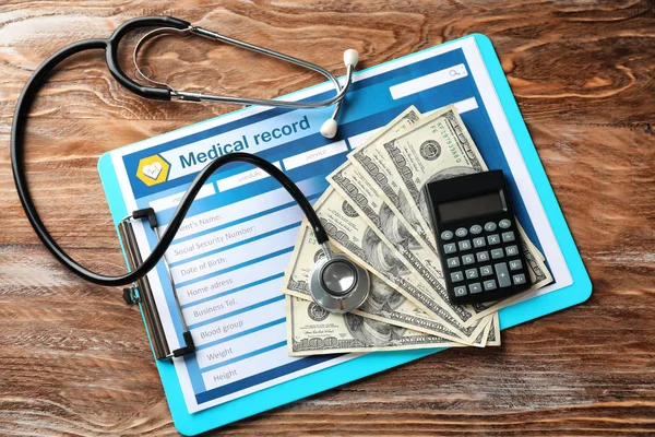 Medical record with stethoscope, money and calculator on table. Health care concept — Stock Photo, Image