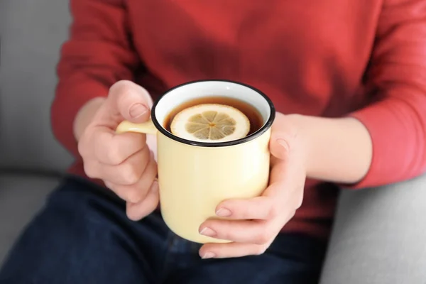 Jeune femme tenant une tasse de thé aromatique chaud au citron, gros plan — Photo