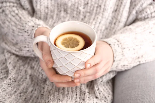 Νεαρή γυναίκα κρατώντας κούπα ζεστό αρωματικό τσάι με λεμόνι, κοντινό πλάνο — Φωτογραφία Αρχείου