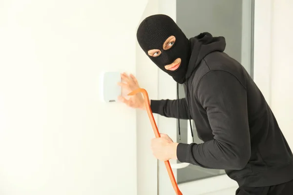 Ladro maschio con piede di porco rompere il sistema di sicurezza all'interno — Foto Stock