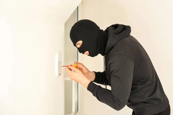 Dieb bricht Sicherheitssystem mit Schraubenzieher im Haus auf — Stockfoto